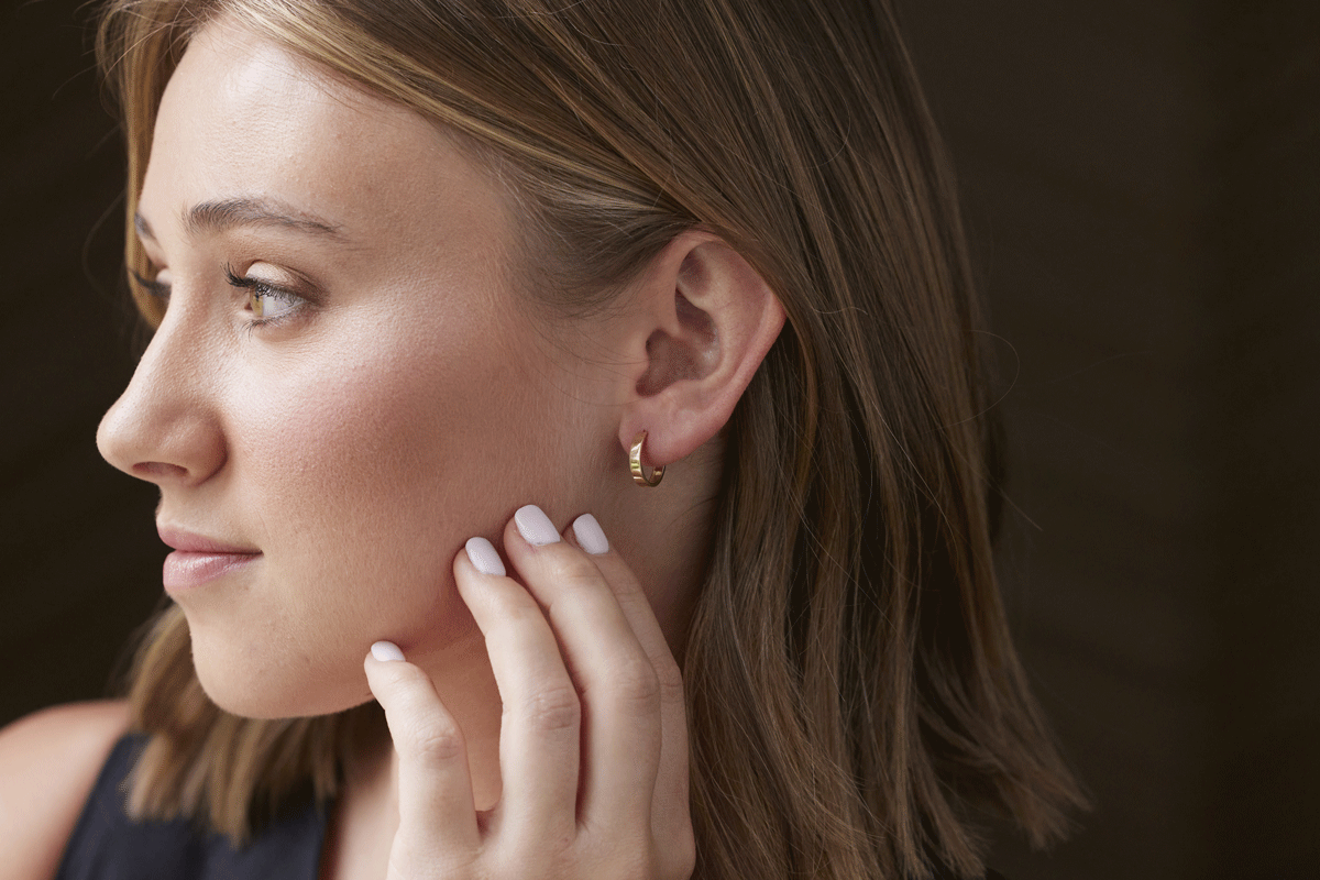 Young female with tiny flat-shaped gold earring