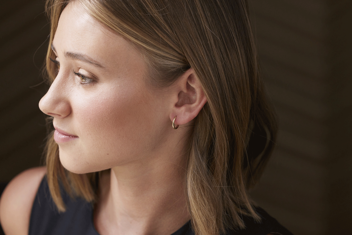 Woman with tiny gold hoop earrings