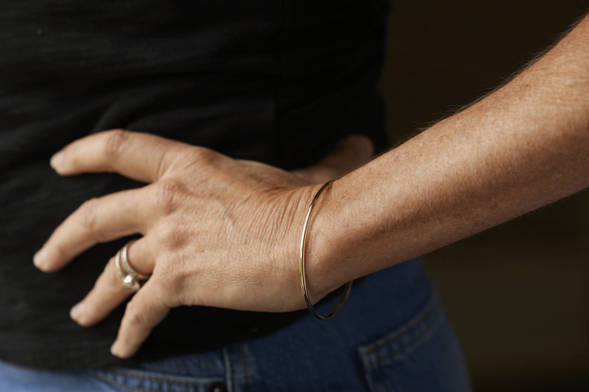 Female arm and wrist with single thin gold bangle bracelet