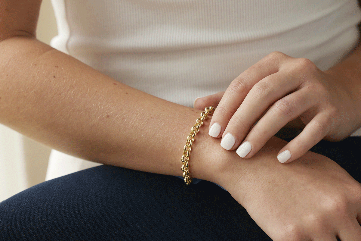 Female hands and arm with gold chunky chain bracelet