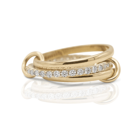 Thin diamond band surrounded by two gold rings connected by tiny loops on a white background