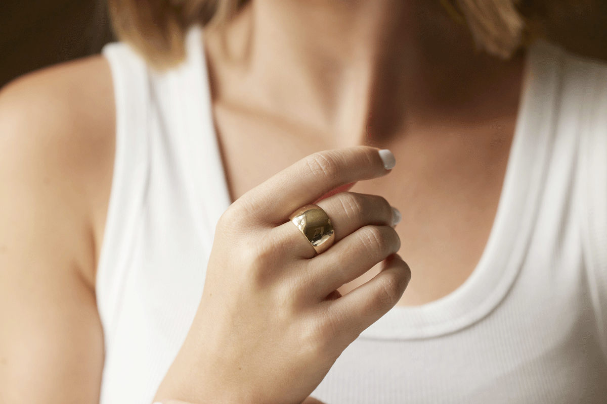 Shiny gold domed ring on woman's hand