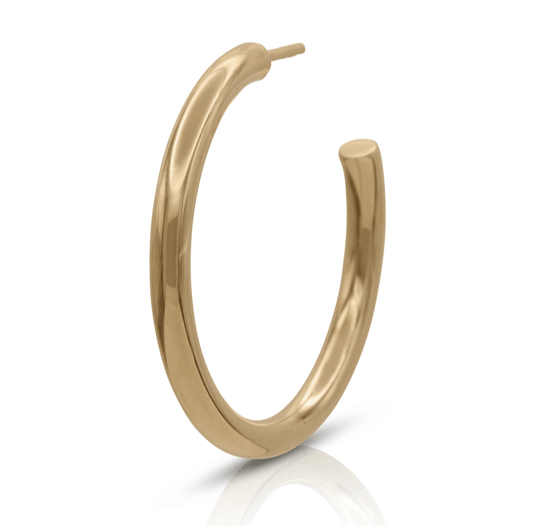 Large simple gold hoop earring on a white background