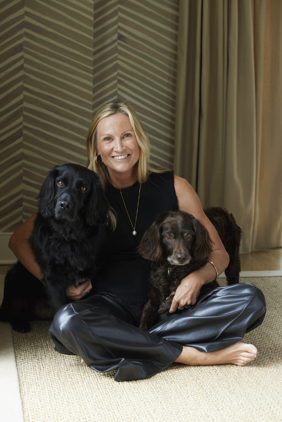 Blond woman sitting on the floor with her two dogs
