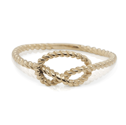 Gold textured love knot ring on a white background