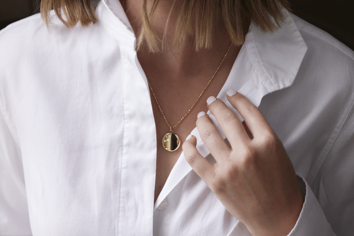 Woman wearing a gold locket necklace