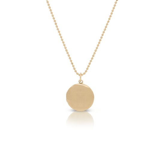 Small gold locket on a thin beaded necklace