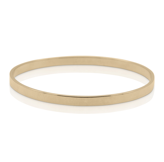 Thick gold bangle bracelet on white background